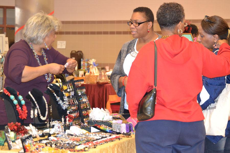 Customers shop for jewelry at a vendors table at the first annual Holiday Bazaar.