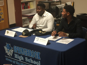 Loic Nya and Tyler Beckwith sign letters of intent in the career center.