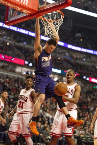 The Phoenix Suns Devin Booker (1) hangs from the basket after dunking against the Chicago Bulls on Friday, Feb. 24, 2017, at the United Center in Chicago. (Erin Hooley/Chicago Tribune/TNS)