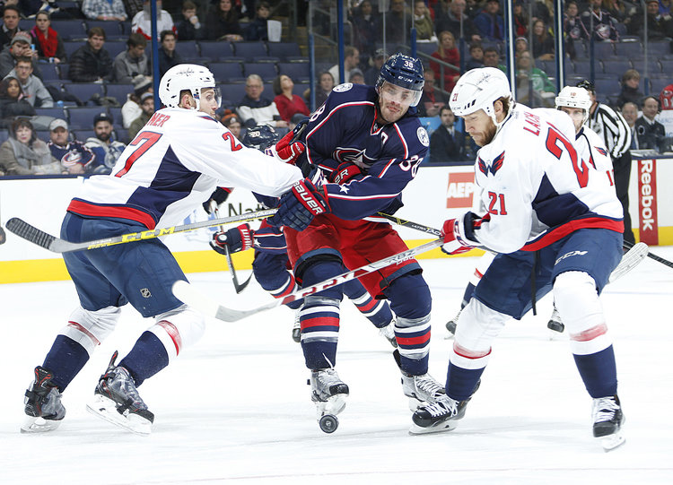 The Columbus Blue Jackets Boone Jenner (38) is sandwiched by the Washington Capitals Karl Alzner (27) and Brooks Laich (21) in the third period at Nationwide Arena.