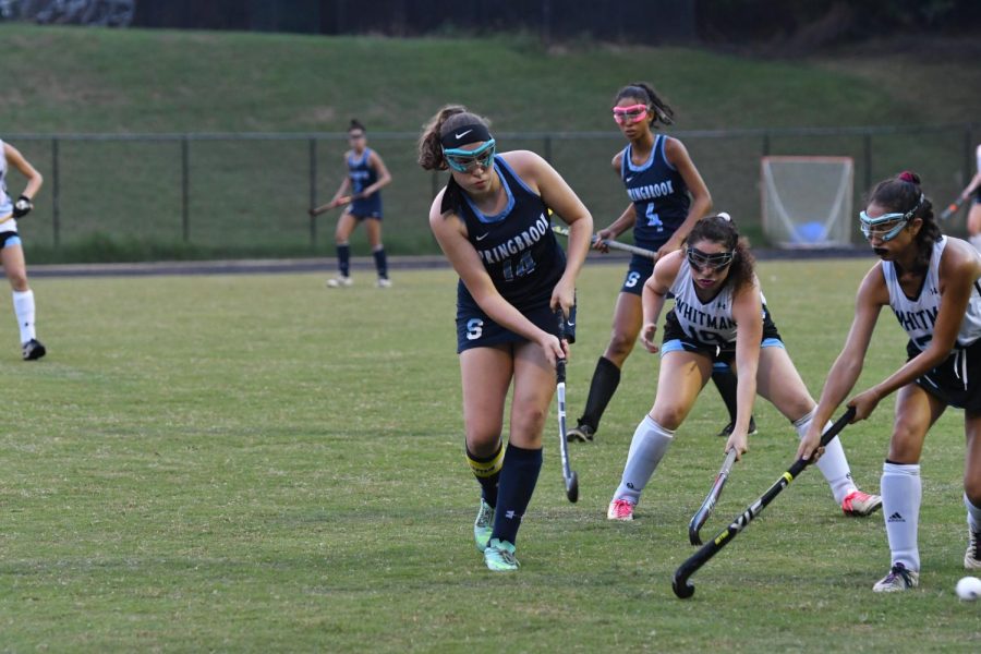 Jamie Ballard of the Varsity Field Hockey team makes a successful pass through Whitman defenders. 