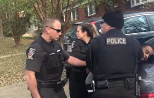 Ahmed is seen being pushed against the hood of a car by multiple Montgomery County police officers. 